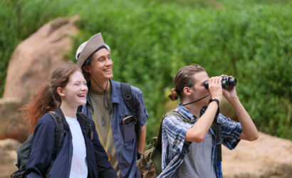 Hikers walking along a trail on a mountain with hiking sticks